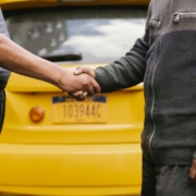 Side view of crop ethnic anonymous males shaking hands while meeting each other on street