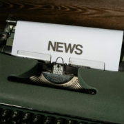 a close up of a typewriter with news paper on it