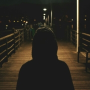 person wearing hooded jacket walking in bridge